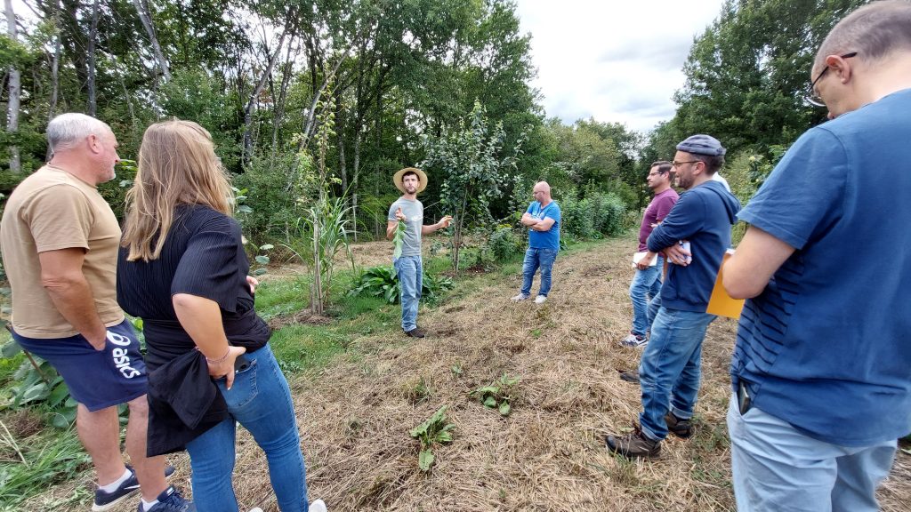 Julian Blight explique l'intérêt de plantes vivaces et de l'herbe entre les rangs de fruitiers.